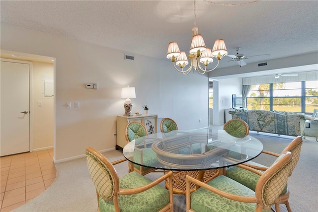 carpeted dining room with tile patterned floors, visible vents, ceiling fan with notable chandelier, and a textured ceiling