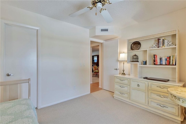 bedroom with visible vents, light colored carpet, a textured ceiling, and ceiling fan