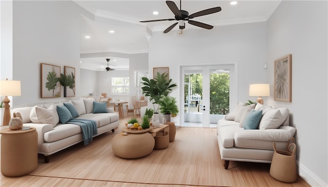 living room with ceiling fan, light hardwood / wood-style floors, a high ceiling, and ornamental molding