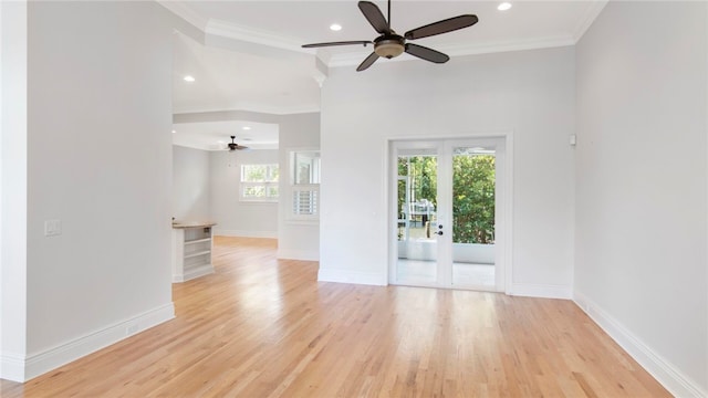 spare room with light hardwood / wood-style floors, a wealth of natural light, crown molding, and ceiling fan