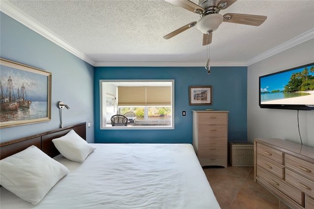 bedroom with a textured ceiling, tile patterned flooring, ornamental molding, and ceiling fan