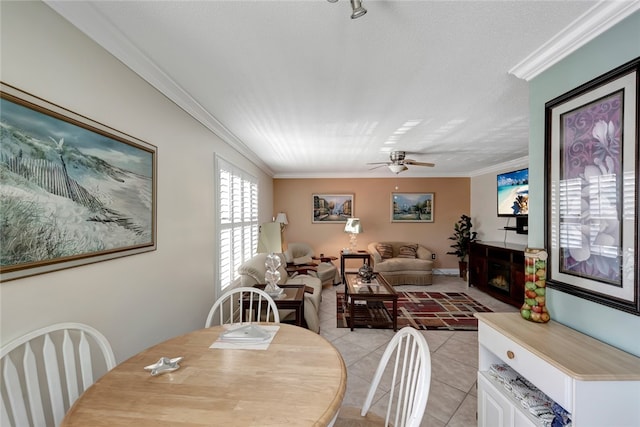 dining room with ceiling fan, a textured ceiling, light tile patterned floors, and ornamental molding