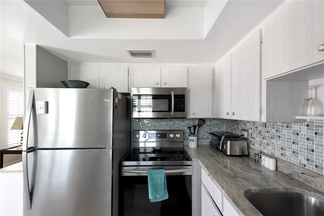 kitchen with sink, appliances with stainless steel finishes, and tasteful backsplash