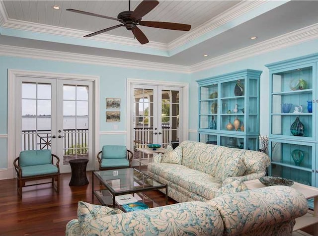 interior space featuring crown molding, dark wood-type flooring, ceiling fan, a tray ceiling, and french doors