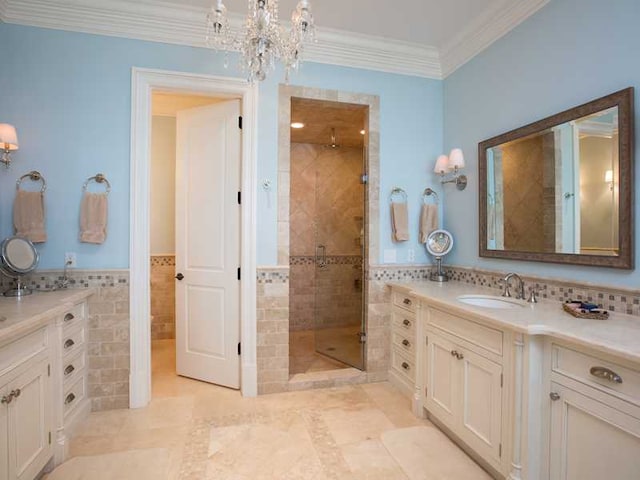 bathroom featuring crown molding, tile walls, vanity, a tile shower, and a chandelier