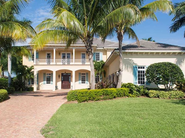 view of front of house with a balcony and a front lawn