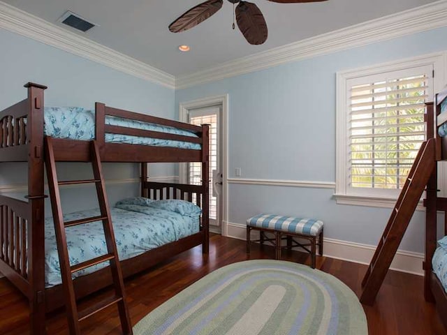 bedroom featuring dark hardwood / wood-style flooring, ornamental molding, and ceiling fan