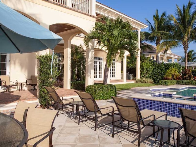 view of patio / terrace featuring an in ground hot tub and french doors