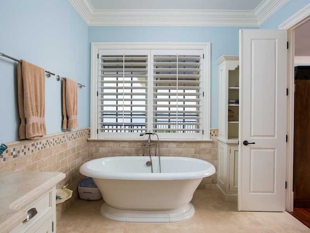 bathroom with vanity, a bath, ornamental molding, and tile walls