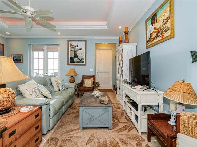 living room with ceiling fan, a raised ceiling, and ornamental molding