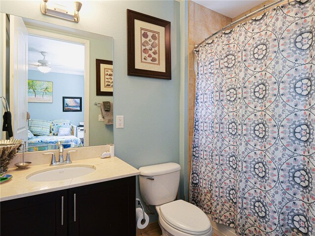 bathroom with toilet, vanity, a shower with shower curtain, and ceiling fan