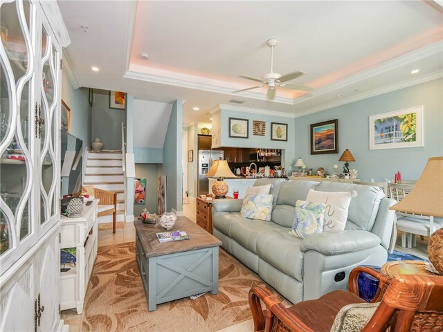 living room with crown molding, ceiling fan, and a raised ceiling