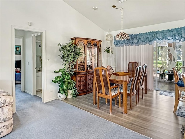 dining room with lofted ceiling and baseboards