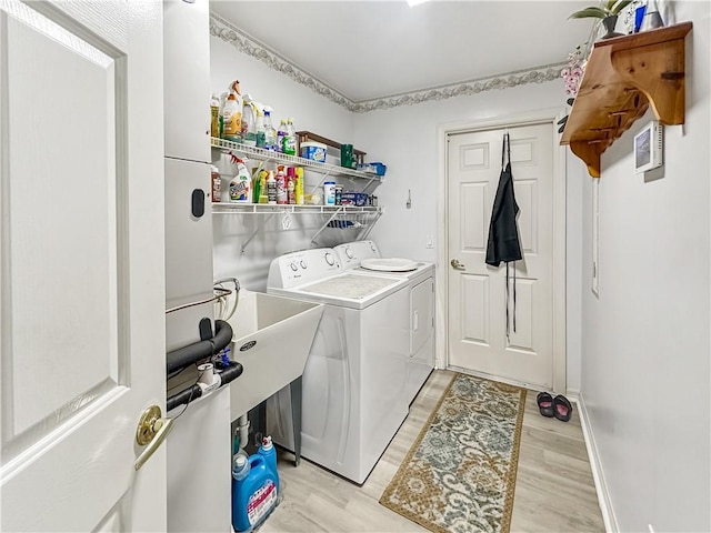 laundry room featuring washer and dryer, light wood finished floors, and laundry area
