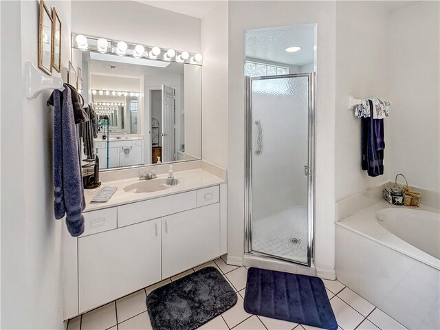 bathroom with a wealth of natural light, a shower stall, a garden tub, and vanity