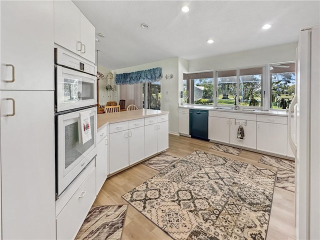 kitchen with light countertops, recessed lighting, white cabinetry, and white appliances