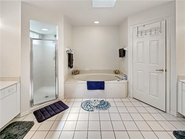 bathroom featuring tile patterned floors, a garden tub, vanity, and a stall shower