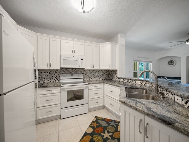 kitchen with white appliances, white cabinets, sink, and light tile patterned floors