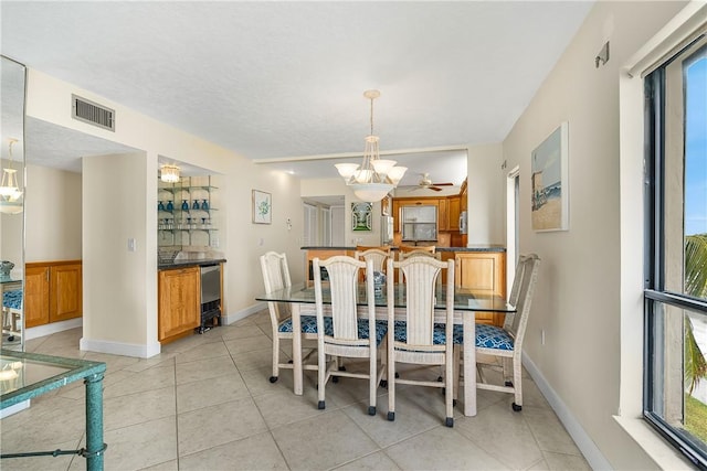 dining area with light tile patterned flooring and ceiling fan with notable chandelier