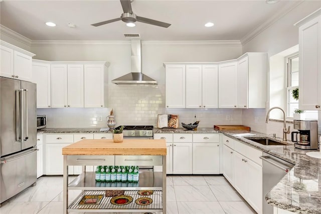 kitchen with decorative backsplash, sink, wall chimney range hood, and appliances with stainless steel finishes