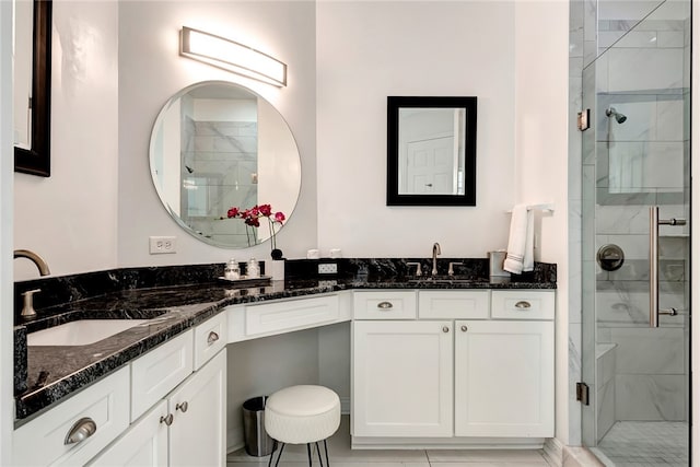 bathroom featuring a shower with door and vanity