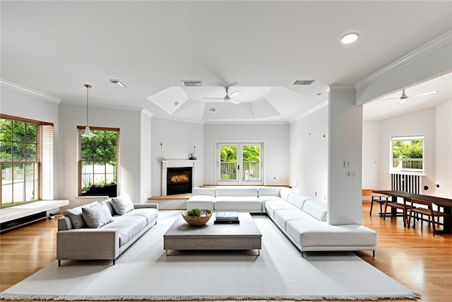 living room featuring ceiling fan, light wood-type flooring, crown molding, and lofted ceiling