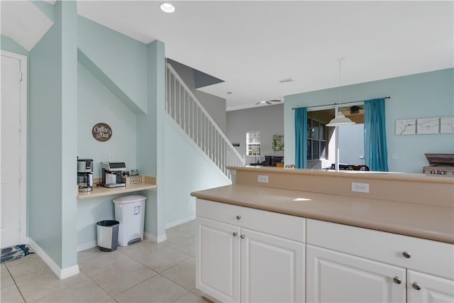 kitchen featuring hanging light fixtures, plenty of natural light, light tile patterned floors, and white cabinets