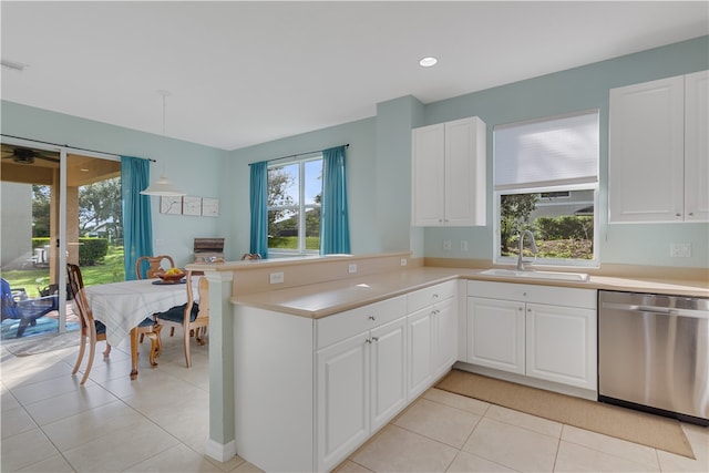 kitchen featuring sink, stainless steel dishwasher, kitchen peninsula, pendant lighting, and white cabinets