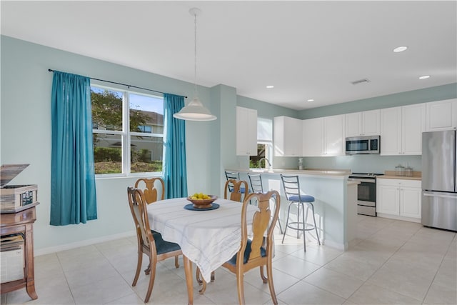 tiled dining room with a healthy amount of sunlight