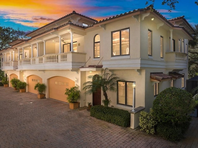 mediterranean / spanish-style house featuring a balcony, a garage, and ceiling fan