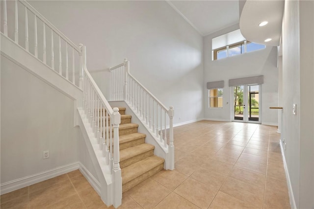 tiled entrance foyer with a towering ceiling