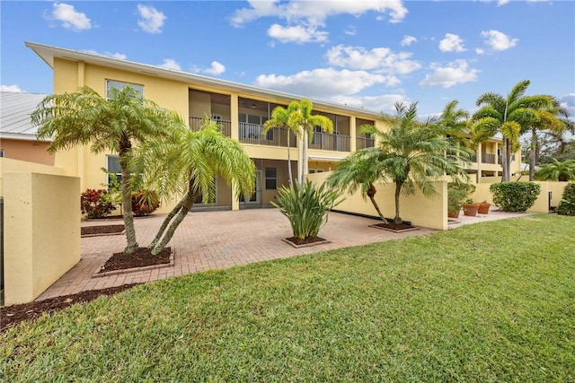 exterior space with a yard, a balcony, and a patio