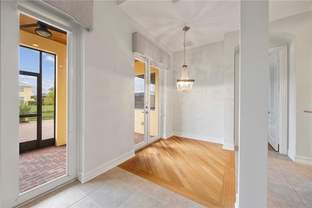 interior space featuring light tile patterned floors, french doors, and a chandelier