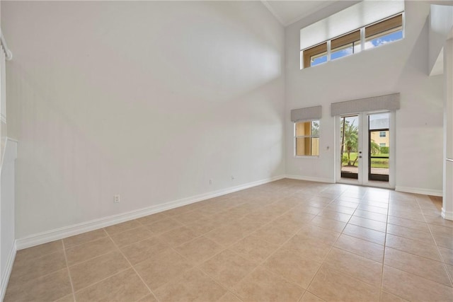 interior space featuring a towering ceiling and light tile patterned flooring