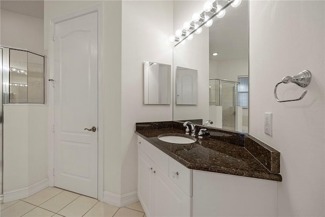 bathroom with tile patterned floors, vanity, and a shower with door