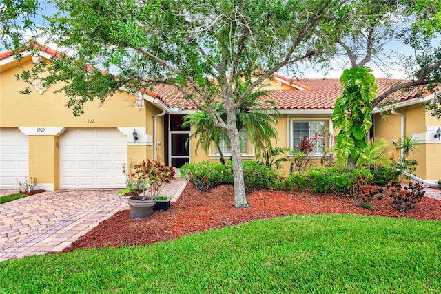 ranch-style home with a garage and a front lawn