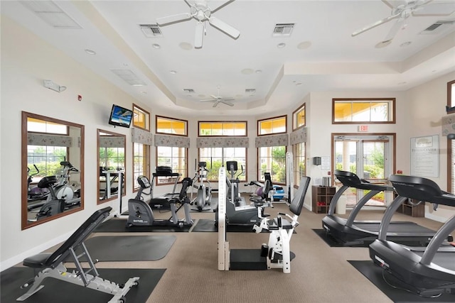 gym with a raised ceiling, ceiling fan, and a towering ceiling