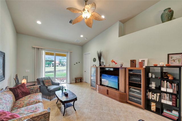 tiled living room with vaulted ceiling, ceiling fan, and a fireplace