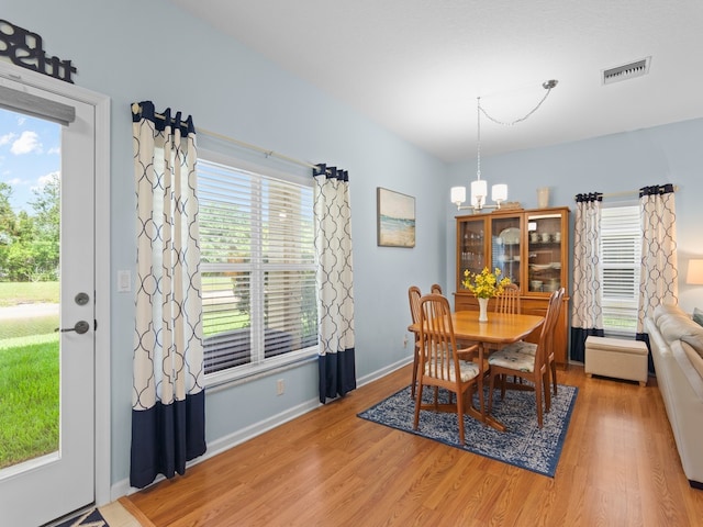 dining room with visible vents, baseboards, an inviting chandelier, and light wood-style flooring