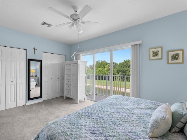 carpeted bedroom with visible vents, multiple closets, ceiling fan, and access to outside