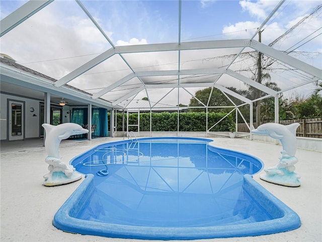 view of swimming pool with glass enclosure and a patio