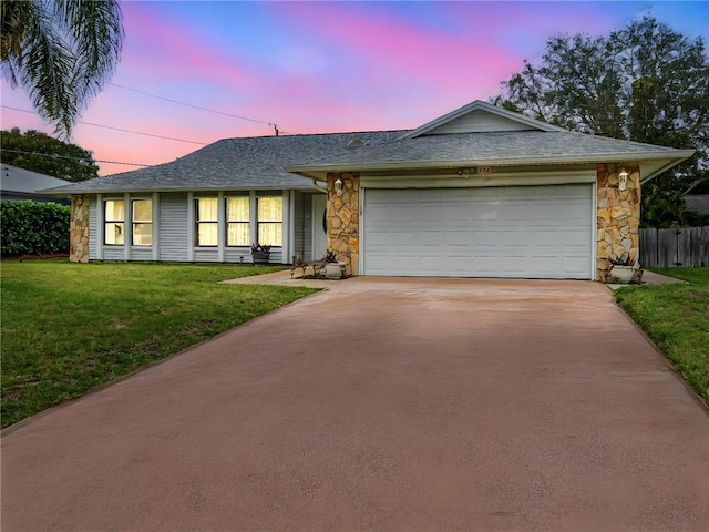 ranch-style house featuring a yard and a garage