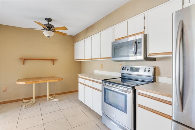 kitchen with light tile patterned flooring, light countertops, a ceiling fan, white cabinetry, and appliances with stainless steel finishes