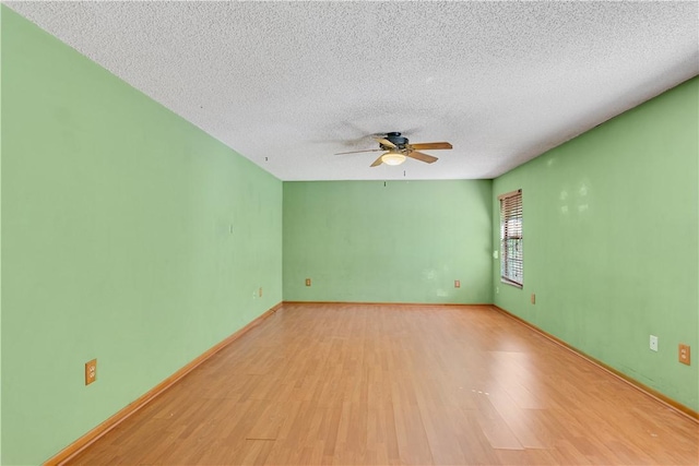 unfurnished room with light wood finished floors, a textured ceiling, baseboards, and a ceiling fan