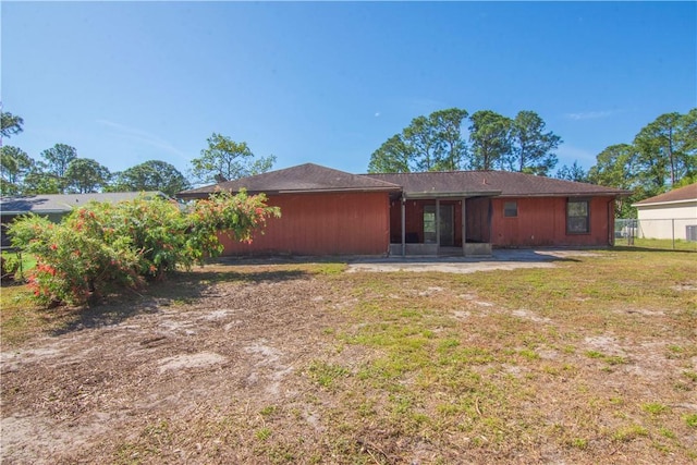 rear view of property with a patio area, a lawn, and fence