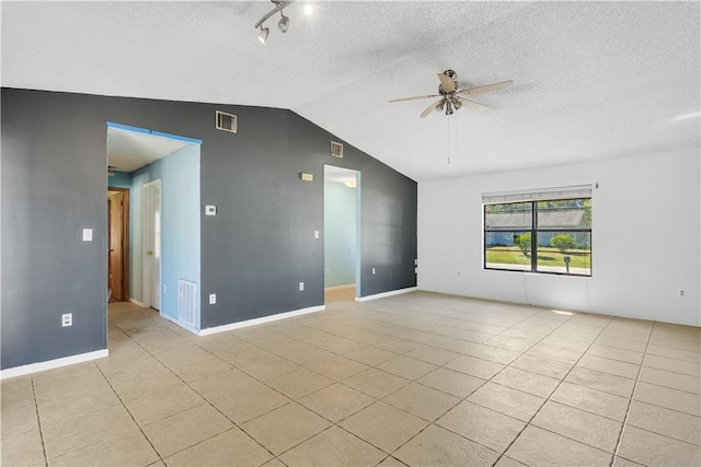 spare room with a textured ceiling, visible vents, ceiling fan, lofted ceiling, and light tile patterned floors