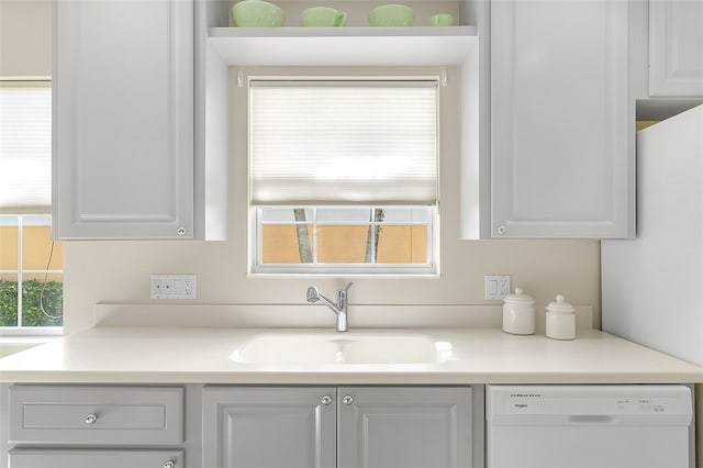 kitchen with white cabinets, a wealth of natural light, sink, and white dishwasher