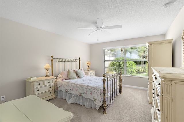 bedroom with a textured ceiling, ceiling fan, and light carpet