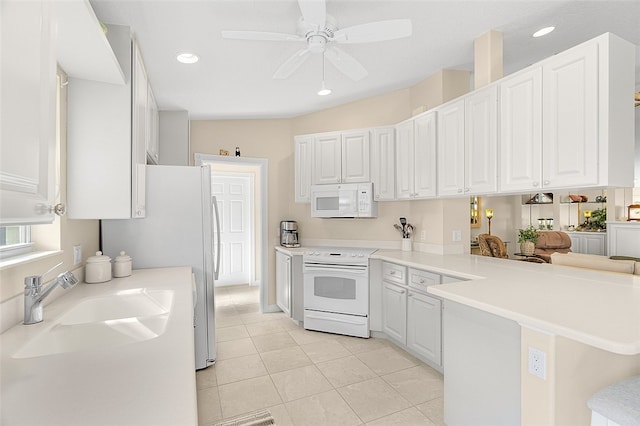 kitchen featuring kitchen peninsula, white appliances, white cabinetry, and sink