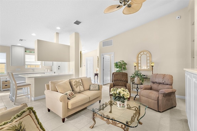 tiled living room with a textured ceiling, ceiling fan, and lofted ceiling